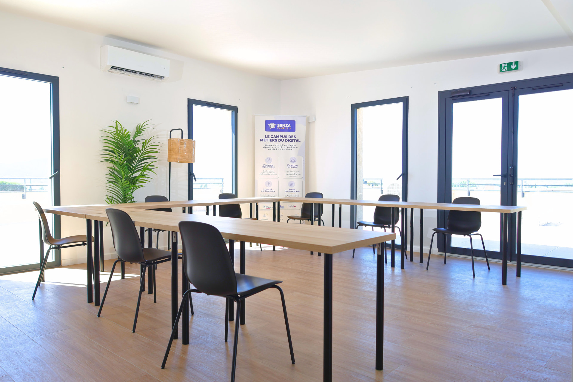 Salle de formation lumineuse du campus SENZA de Toulon avec tables en U et kakémono SENZA Campus IA